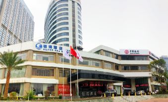 a modern hotel building with multiple flags flying in front of it , including the chinese flag at Silver Sea Hotel