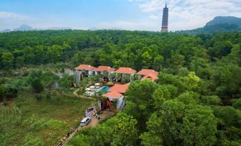 a bird 's eye view of a resort surrounded by trees with a tall tower in the background at Bai Dinh Garden Resort & Spa