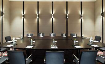 A spacious conference room is available, furnished with black chairs and a long table that can accommodate up to six people at Four Points by Sheraton Qingdao, West Coast