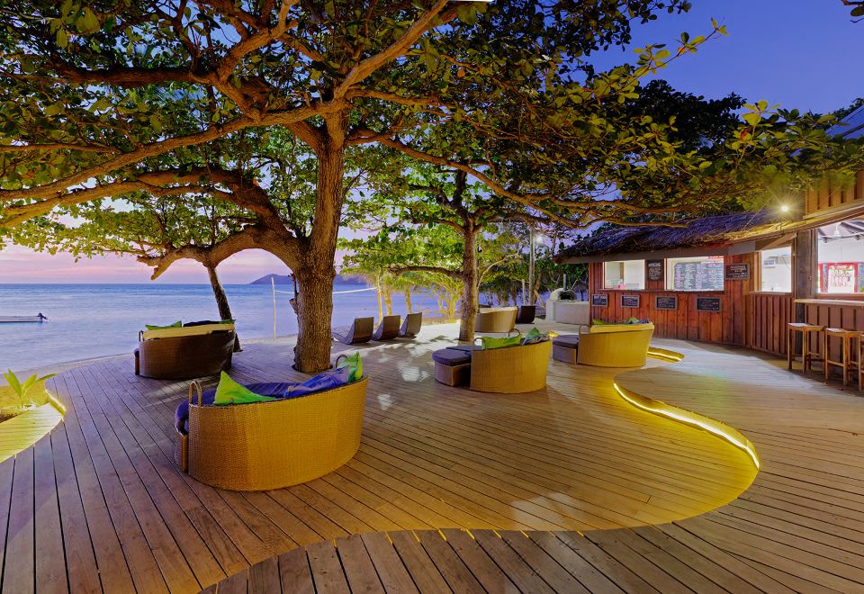 a wooden deck overlooking a body of water , with several chairs placed around the area at Mantaray Island Resort