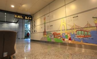 There is a large mural on the wall in an office lobby that includes a children's play area and other features at Guangzhou Baiyun Airport Passenger Time Lounge (T1 Terminal Store)