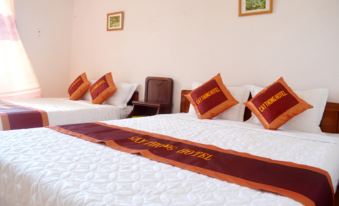 a room with three beds , two of which are on the left side of the room and one on the right side at Cay Thong Hotel