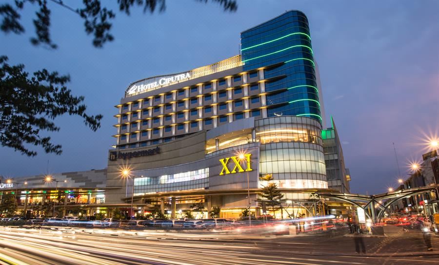 a large hotel building situated on the side of a busy city street , surrounded by traffic at Hotel Ciputra Cibubur Managed by Swiss-Belhotel International