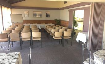 a conference room with rows of chairs arranged in a semicircle , ready for a meeting at Lindy Lodge Motel