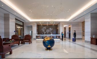 The modern lobby of the hotel features a large chandelier and marble countertops at Kaili Yade Hotel(Dongguan Huangjiang Jinyi Branch)