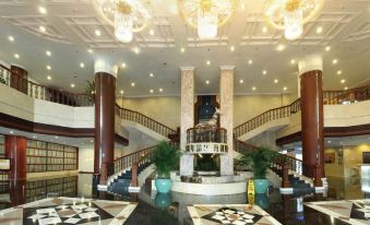 a grand hotel lobby with two grand staircases , a grand chandelier , and marble floors at Silver Sea Hotel
