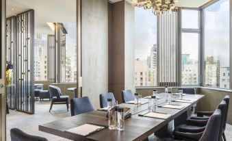elegant chandelier hanging from the ceiling, creating a sophisticated and spacious atmosphere for guests to enjoy their meals and gatherings at Hyatt Centric Victoria Harbour Hong Kong