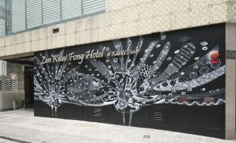 A mural on a side wall in an urban setting, surrounded by other street art and buildings at Lan Kwai Fong Hotel @ Kau U Fong