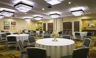 a large banquet hall with several round tables covered in white tablecloths , and chairs arranged around them at Fairfield Inn & Suites by Marriott Tustin Orange County