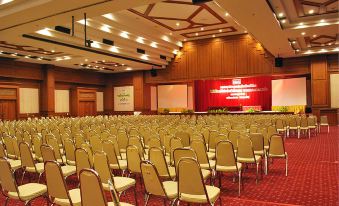 a large conference room with rows of chairs arranged in front of a stage , ready for a meeting or event at Rimpao Hotel