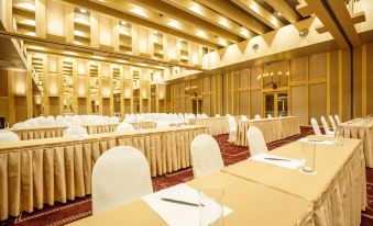 A spacious room is set up with rows of tables for an event at a hotel or conference at Regency Art Hotel