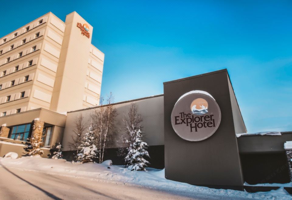 "a large building with a sign that says "" explorer hotel "" is shown in the snow" at The Explorer Hotel