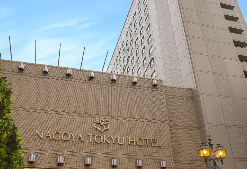 the exterior of a large hotel building , with a staircase leading up to it and a sign above the entrance at Nagoya Tokyu Hotel
