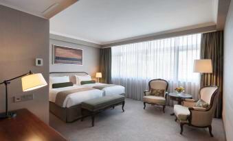 The bedroom is furnished with a bed, table, and large windows at Marco Polo Hongkong Hotel
