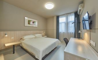 The modern bedroom features a large window and a small desk at one end, creating a bright and functional space at Jinjiang Inn (Shanghai People's Square East Huaihai Road)