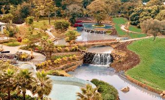 a bird 's eye view of a lush green park with a waterfall and a river at Gran Melia Arusha