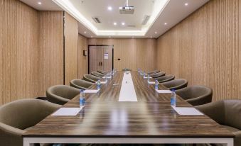 A spacious conference room with a long wooden table and chairs is available for meetings and other business purposes at Nuomo Hotel