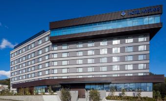 "a large , modern hotel with multiple floors and a blue sign reading "" hotel a "" on the front" at HOTEL MYSTAYS Fuji Onsen Resort