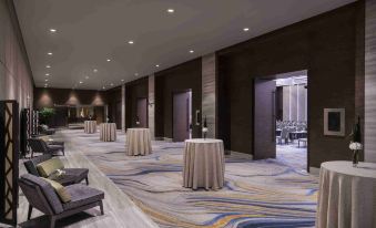 There is a spacious room with tables and chairs located in the center, adjacent to an unoccupied banquet hall at Amara Signature Shanghai