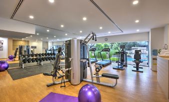 a well - equipped gym with various exercise equipment , including treadmills and weightlifting machines , in a well - lit room at Oakwood Hotel and Residence Kuala Lumpur
