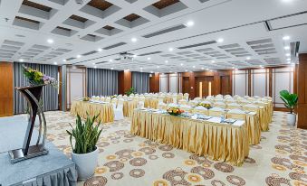 a large , empty conference room with multiple tables and chairs set up for a meeting or event at Paris Deli Danang Beach Hotel