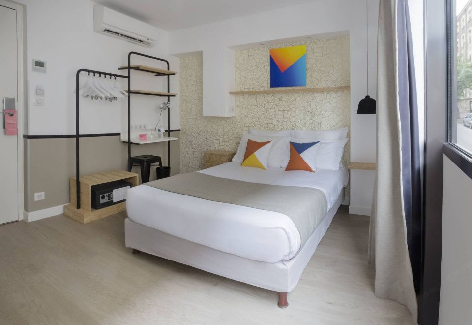 a modern bedroom with a white bed , colorful pillows , and a tv on the wall at Hotel Izzy