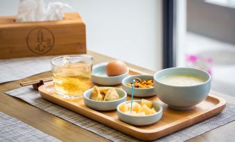 a wooden tray with a glass of tea , cups of tea , and various side dishes at yhz
