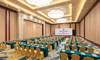 A spacious room is arranged with blue chairs and tables for an event at the hotel at Ramada by Wyndham Heze
