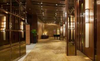 There is a hallway with two doors, ceiling lights, and an entrance to another area at Marco Polo Hongkong Hotel