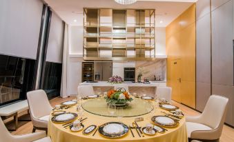 There is a dining room with a large table and four chairs set in front of the kitchen at Sky Bird Hotel (Shanghai Hongqiao Airport)
