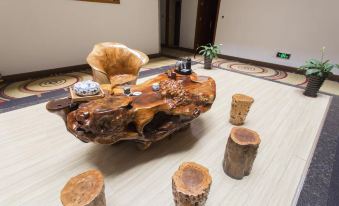 The room features wooden furniture and a unique coffee table made from real tree trunks at Kaiserdom Hotel (Guangzhou Baiyun Airport)