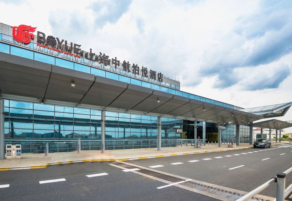 A large building with an outdoor view has a welcoming sign at its entrance at Boyue Hotel Shanghai Air China Hongqiao Airport