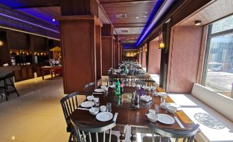 An upscale restaurant features a long table and chairs in the middle room, adorned with wood paneling at Mutianyu Great Wall Hotel