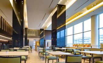 a large , modern restaurant with multiple dining tables and chairs , as well as a kitchen area at Centrair Hotel