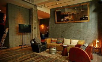 In the living room, there are two chairs and an entertainment center in front of the television, which is mounted on the wall at URBN Boutique Shanghai