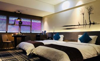 The bedroom is decorated and includes two large beds and a table by the window at Likto Hotel (Guangzhou Taojin Metro Station)