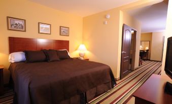 a large bed with a brown comforter is in the middle of a room with two lamps on either side at Moenkopi Legacy Inn & Suites