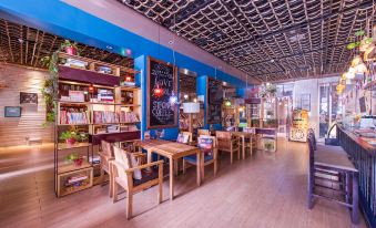 a cozy bookstore with wooden furniture , a blue ceiling , and various books arranged on shelves at GuiLin ParkView Hotel