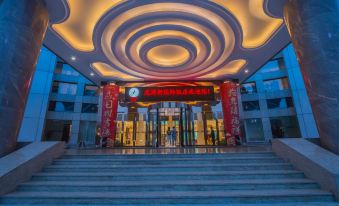 At night, a hotel entrance is adorned with large windows and decorative lighting on both sides at Longyou International Grand Hotel