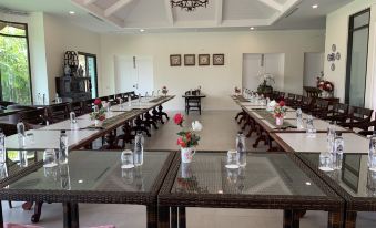 a large dining room with multiple long tables set for a formal event , surrounded by chairs and tables at Content Villa Chiangmai