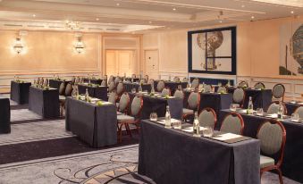a large conference room filled with rows of chairs and tables set up for a meeting or event at Auberge du Jeu de Paume