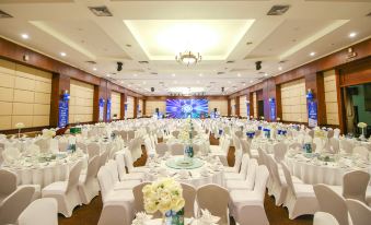 a large banquet hall with multiple tables set up for a formal event , possibly a wedding or conference at Sai Gon Ha Long Hotel