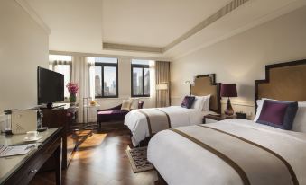The bedroom is furnished with large windows, beds, and a desk in the middle at Jinjiang Metropolo Hotel Classiq, Shanghai Bund Circle