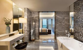 a luxurious bathroom with a marble floor , a large bathtub , and a view of the ocean at Sanya Xizang Hotel