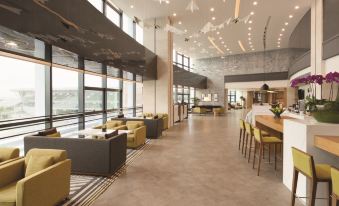 The lobby features tables and chairs arranged in the center, complementing the open concept floor plan at Hyatt Place Shenzhen Airport