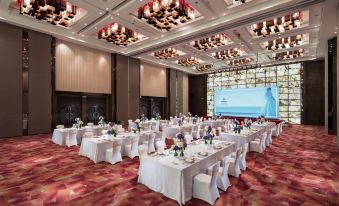 The ballroom is decorated and set up with tables and chairs for an event at Hilton Guangzhou Tianhe