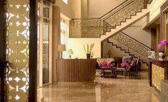 a spacious living room with a curved counter , wooden flooring , and a staircase leading to the upper level at Sapphire Sky Hotel & Conference