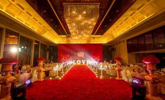 A ballroom is set up with red carpet and tables for an event or wedding at Wansheng International Hotel