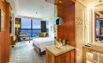 The room features large windows, a centrally located bed, and an attached bathroom at Swissotel Foshan Guangdong