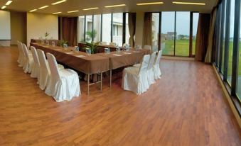 a conference room set up for a meeting , with tables and chairs arranged in a semicircle at The Pade Dive Resort